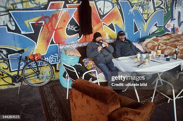 Deutschland, Berlin - Moabit, Obdachlose kampieren unter der Hansa-Brücke, mit Decken, Esstisch, Haushaltsutensilien, Reinigungsgeräten, Sofa und...