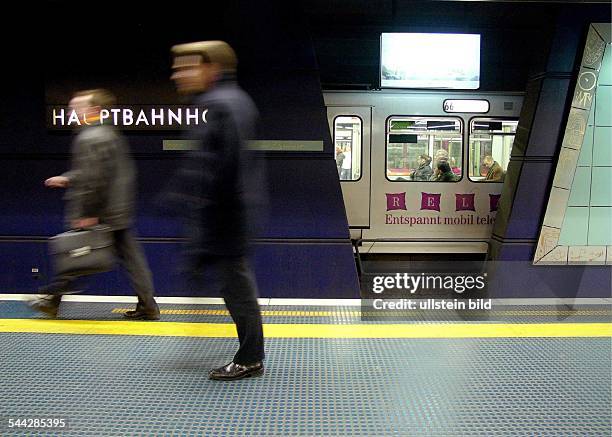 Deutschland, Nordrhein-Westfalen, Bonn, U-Bahnhof Station Hauptbahnhof. Hastende Passanten auf dem Bahnsteig und eine an der Haltestelle wartende...