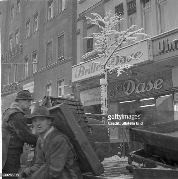 Deutschland, Berlin, Kohlentraeger liefern Briketts in Kaesten fuer Ofenheizung. - Winter 1962 / 1963