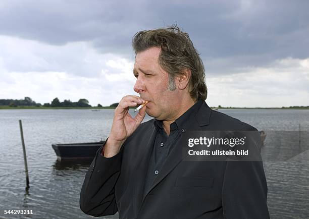 Jan Fedder - Schauspieler, bei Dreharbeiten in Waase auf der Insel Ruegen mit Zigartette