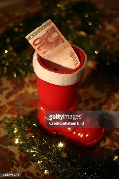 Symbol Weihnachtsgeschenke, Geldgeschenke, Weihnachstgeld, Kuerzung des Weihnachtsgelds, Nikolausstiefel mit 10 Euro Geldschein