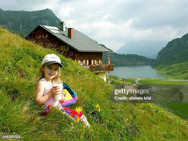 Alpen, Alpenmilch, Maedchen sitzt mit einem Glas Milch auf der Alm