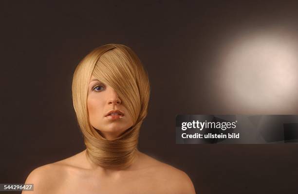 Haare, Haarpflege: Frau langen blonden Haaren um den Kopf geschlungen.