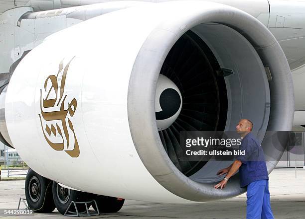 Deutschland, Sachsen, Dresden - Ein Flugzeugmechaniker der EADS Elbe Flugzeugwerke GmbH schaut in ein Triebwerk eines fuer die Emirates SkyCargo...