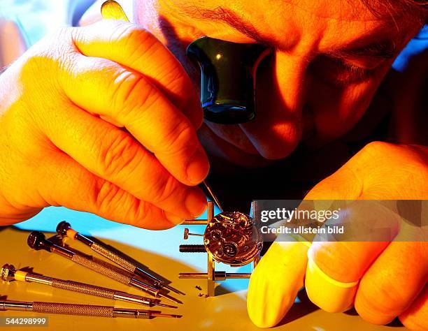 Deutschland, Uhrmachermeister mit Lupe arbeitet an einem Uhrwerk der Firma Glashuette / Sachsen .- 2005