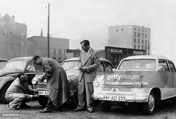 Deutschland, Hamburg Autoverkaeufer bringen neue Nummernschilder an einem Borgward Lloyd an. Entfernt wurden die Kennzeichen der britischen...