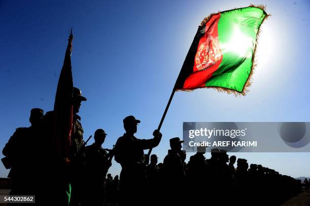 Afghan National Army soldiers stand to attention during a ceremony at the military base in Herat on July 3, 2016. - Around 1000 soldiers trained for...