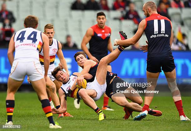 Rory Atkins of the Crows is tackled by Jack Viney of the Demons during the round 15 AFL match between the Melbourne Demons and the Adelaide Crows at...