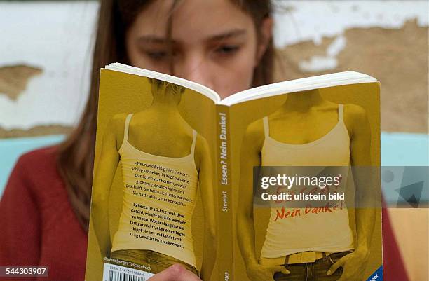 Essstörungen, Magersucht, Mädchen liest das Buch "Essen? Nein Danke!"