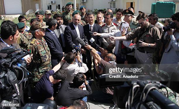 Afghan chief of national Security Council Mohammad Hanif Atmar and Chinese ambassador to Kabul Yao Jing speak during the handover ceremony as China...