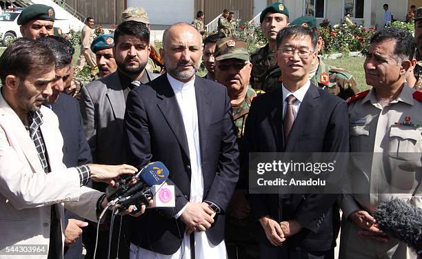 Afghan chief of national Security Council Mohammad Hanif Atmar and Chinese ambassador to Kabul Yao Jing speak during the handover ceremony as China...