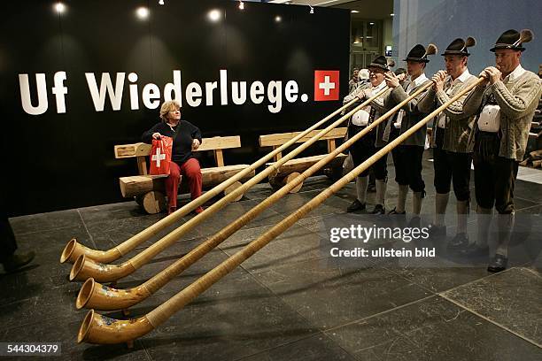 Deutschland, Berlin, Grüne Woche 2006. "Günztaler Alphornbläser" in der Schweizer Halle spielen zum Tagesabschluss vor Schriftzug "Uf Wiederluege"