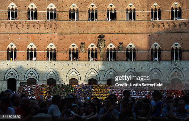 Spectators get an elevated view ahead of a trial race of the historical Italian horse race of the Palio Di Siena on July 01, 2016 in Siena, Italy....
