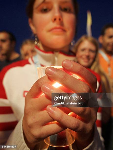 Nordrhein-Westfalen, Koeln - XX. Weltjugendtag 2005 Jugendliche haelt ein Windlicht in den Haenden waehrend eines abendlichen Open Air Gottesdienstes...