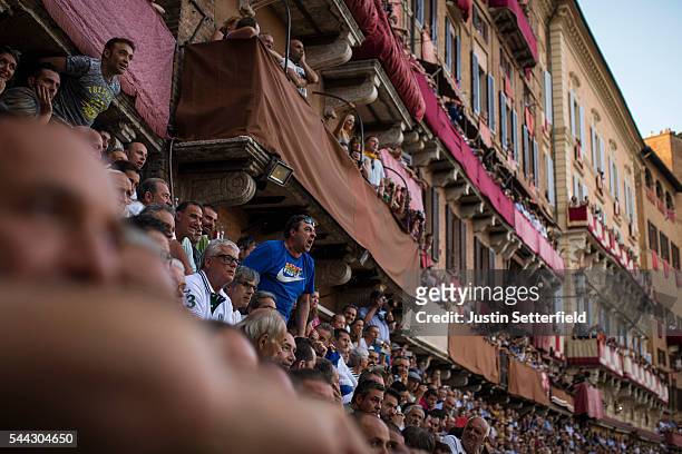 Spectators cheer their horse and jockey during the historical Italian horse race of the Palio Di Siena on July 02, 2016 in Siena, Italy. The Palio di...