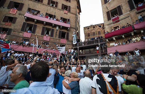 The palio flag is raised to the winning 'contrada of Lupa' after the historical Italian horse race of the Palio Di Siena on July 02, 2016 in Siena,...