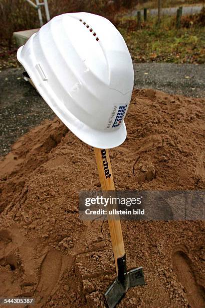 Symbol Erster Spatenstich, Spaten mit Bauhelm