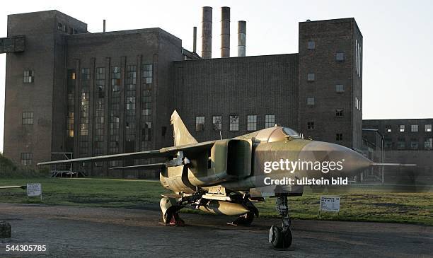 Deutschland, Mecklenburg-Vorpommern, Jagdflugzeug vom Typ MiG-23 der ehemaligen DDR steht vor dem stillgelegten Kraftwerk in Peenemuende. Bis zur...