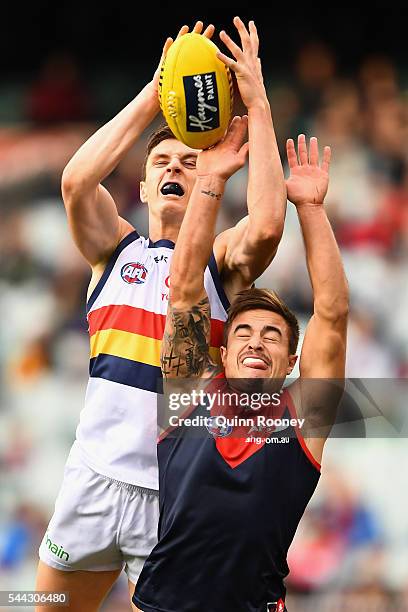 Jake Lever of the Crows marks over the top of Ben Kennedy of the Demons during the round 15 AFL match between the Melbourne Demons and the Adelaide...