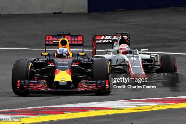 Daniel Ricciardo of Australia driving the Red Bull Racing Red Bull-TAG Heuer RB12 TAG Heuer battles for position with Romain Grosjean of France...