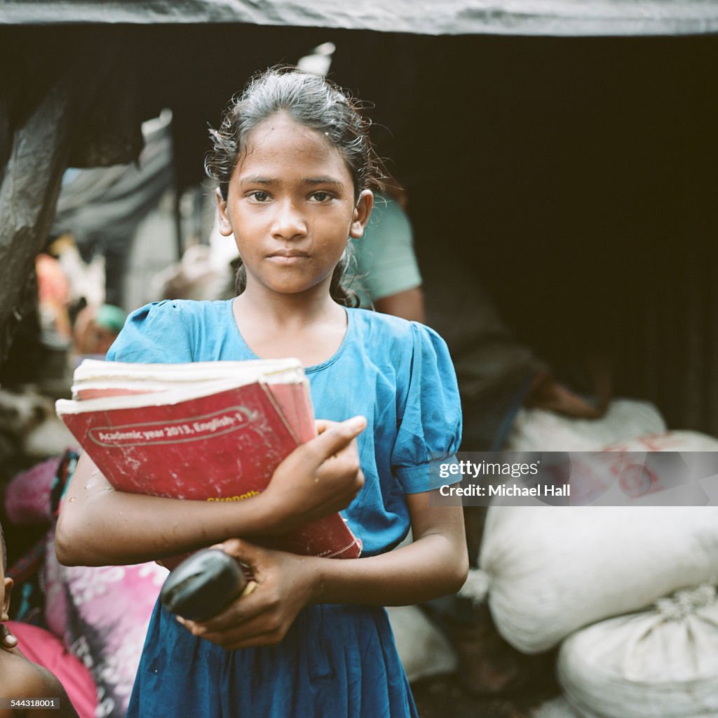 Young girl from slum with school books