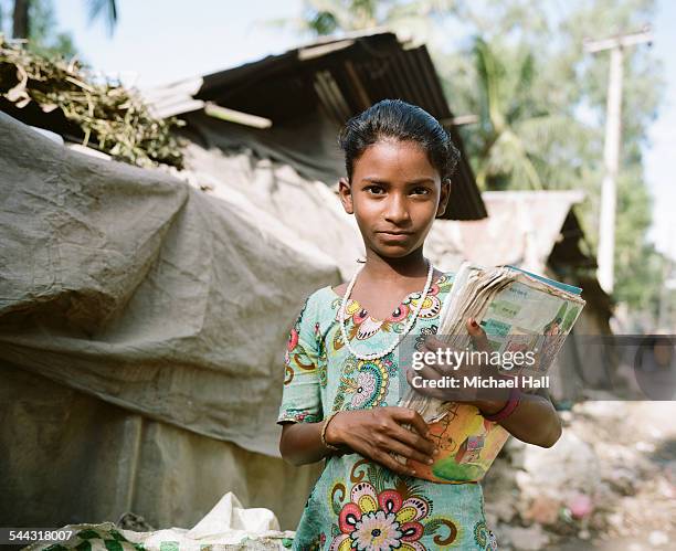 young girl from slum with school books - povertà foto e immagini stock