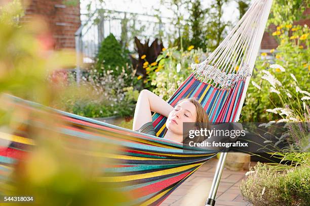young blonde woman relax in hammock, summer, closed eyes - rooftop garden stock pictures, royalty-free photos & images