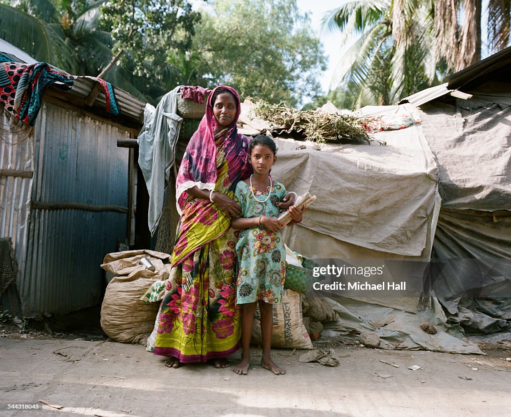 Girl & proud mother from slum holding school books