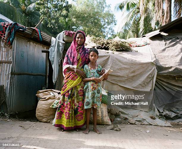girl & proud mother from slum holding school books - bangladesh stock-fotos und bilder