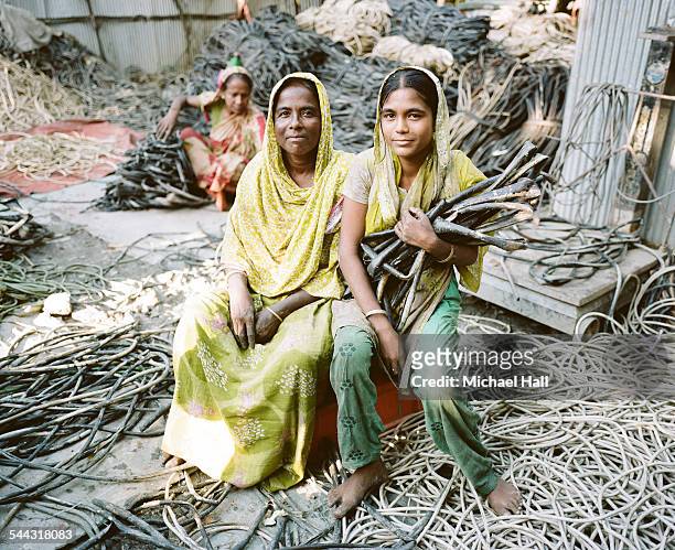 mother & daughter striping copper from cables - chittagong stock pictures, royalty-free photos & images