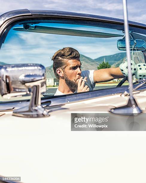 fifties pompadour hair greaser guy smoking driving convertible car - rockabilly stockfoto's en -beelden