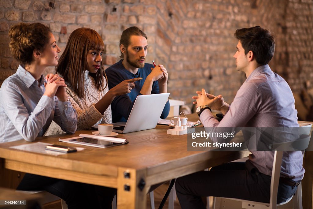 Business people communicating with potential candidate during job interview.