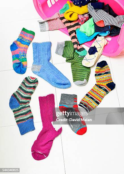 odd socks spilling out of a basket - mismatch stock-fotos und bilder