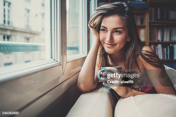 glücklich und komfortabel zu hause am morgen - woman drinking coffee at home stock-fotos und bilder