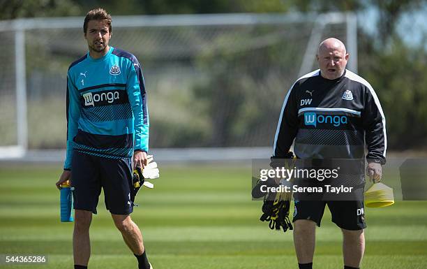 Goalkeeper Tim Krul walks on the pitch with Physiotherapist Derek Wright during a Newcastle United training session at The Newcastle United Training...