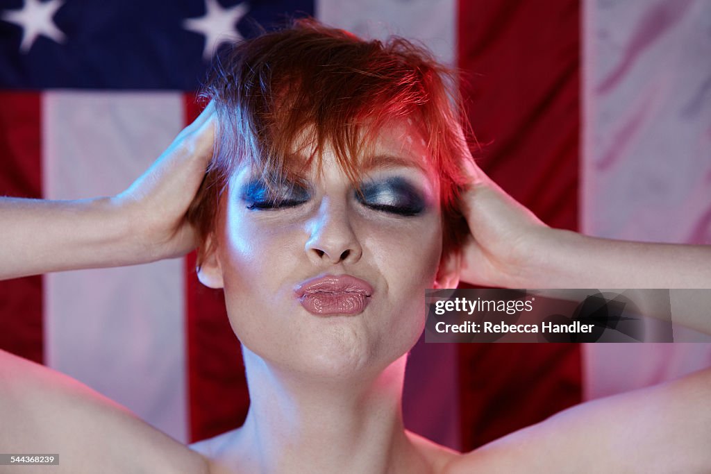 Woman making kiss face american flag backdrop