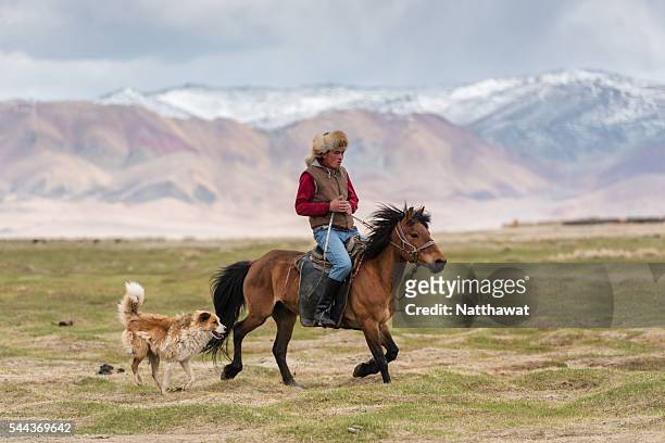 kazakh nomad riding horse with his dog - semi arid stock pictures, royalty-free photos & images