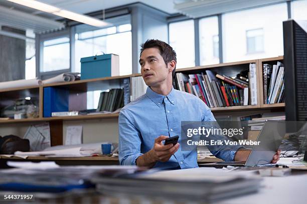 male professional in office holding technology - businessman busy photos et images de collection