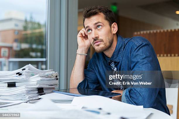 male professional at desk - dubbio foto e immagini stock