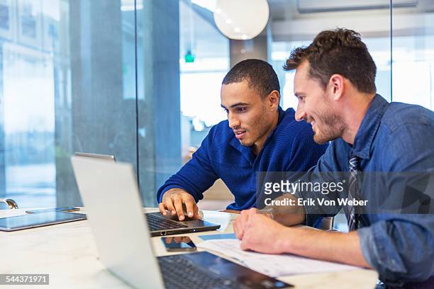 coworkers discussing spreadsheet - homem de azul imagens e fotografias de stock