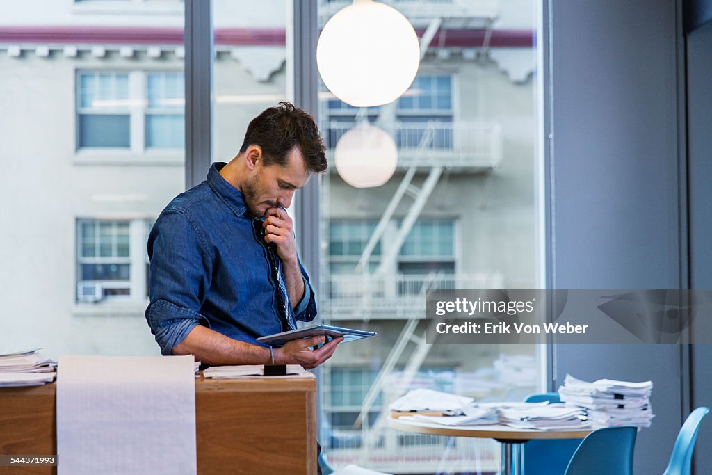 Male colleagues reading digital tablet