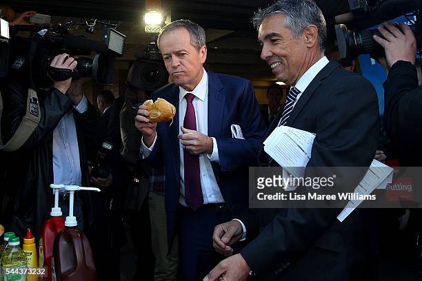 Opposition Leader, Australian Labor Party Bill Shorten enjoys a sausage bread roll during a visit to a polling booth at Strathfield North Public...