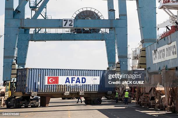 Picture taken on July 3, 2016 shows containers being unloaded from Lady Leyla, a humanitarian aid ship sent from Turkey to the Gaza Strip, at the...