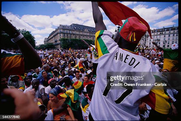 Senegalese fan leads cheers at a 2002 World Cup match as it is broadcast live in the square outside Hotel de Ville in Paris.