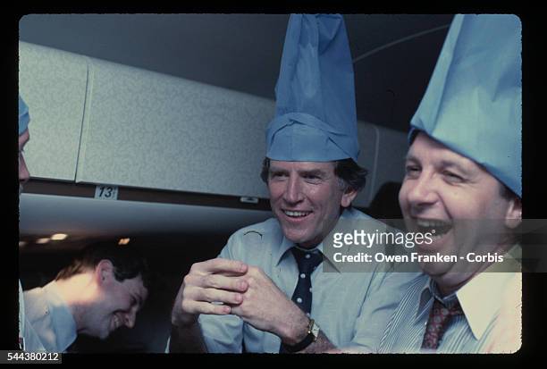 Democratic presidential candidate Gary Hart wears a blue pillowcase on his head and jokes with journalists aboard his campaign airplane during the...