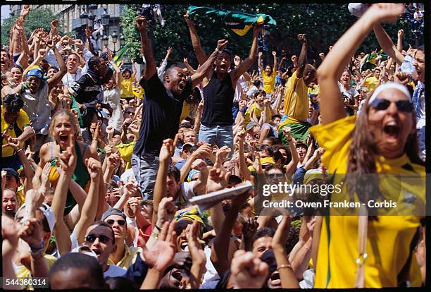 Brazilian soccer fans cheer the 2002 World Cup victory against Germany as they watch a live broadcast in the square outside the Hotel de Ville in...