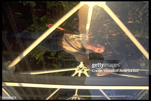 The Biospherian Linda Leigh as seen through one of the glass panels of the enclosed ecosystem Biosphere 2 in Oracle, Arizona, September 26, 1991.