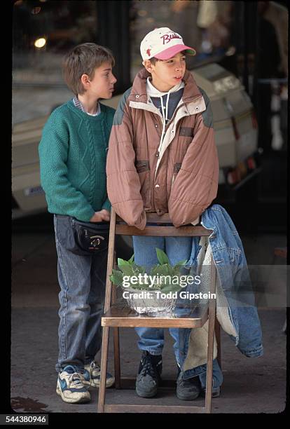 Two boys sell lillies-of-the-valley, a traditional symbol of love and remembrance, for May Day celebrations on a street in Beaune, France.