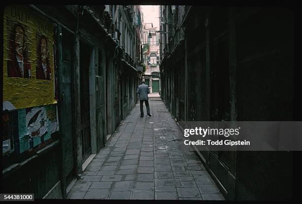 Man Walking Down Narrow Alleway