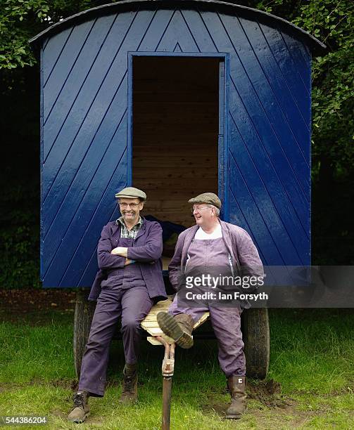 Two friends sit outside their old wooden trailer at the annual Duncombe Park Steam Fair on July 3, 2016 in Helmsley, England. Held in the picturesque...